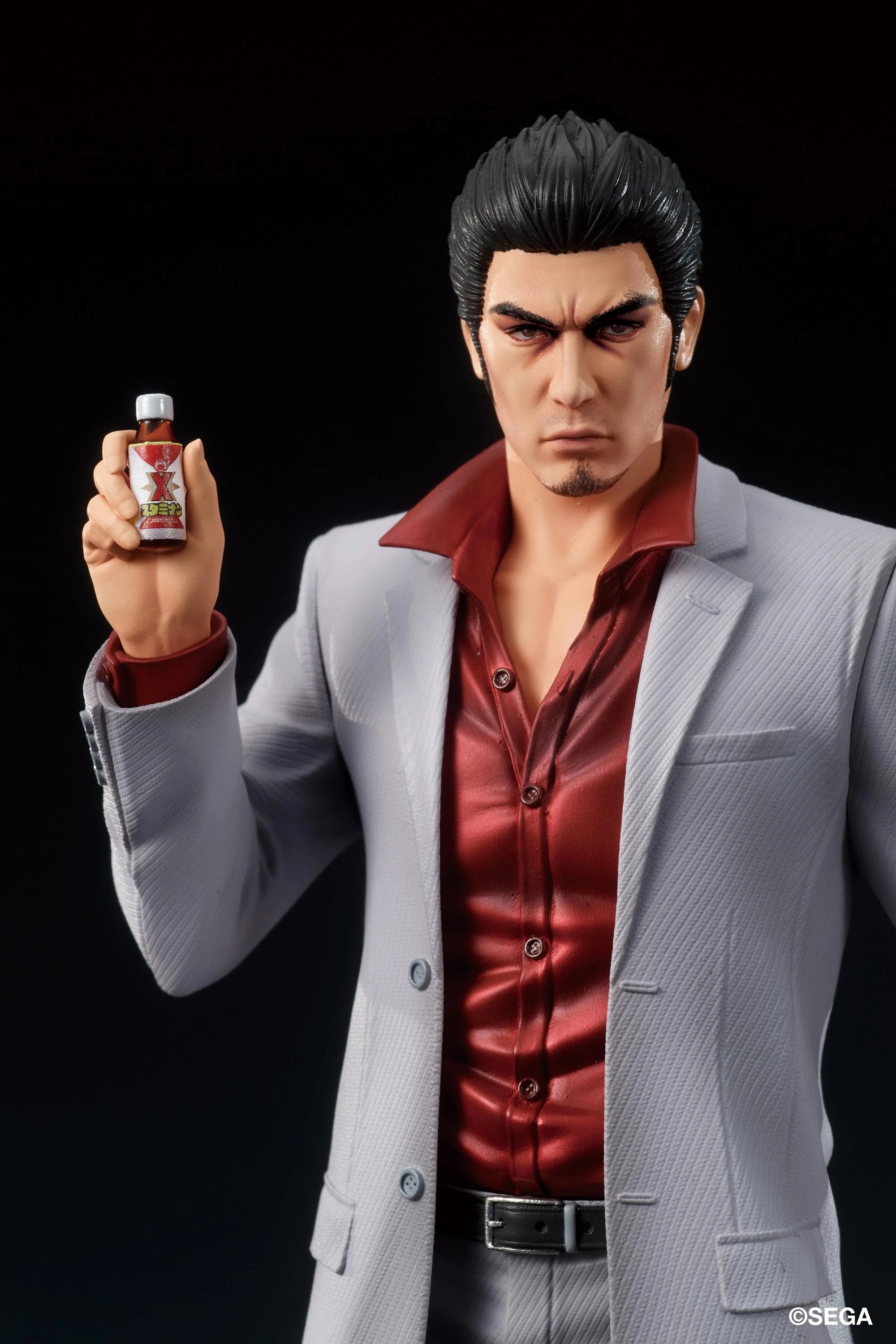A close-up of the Kazuma Kiryu figure's face, showing his intense expression and holding the bottle of Staminan X.