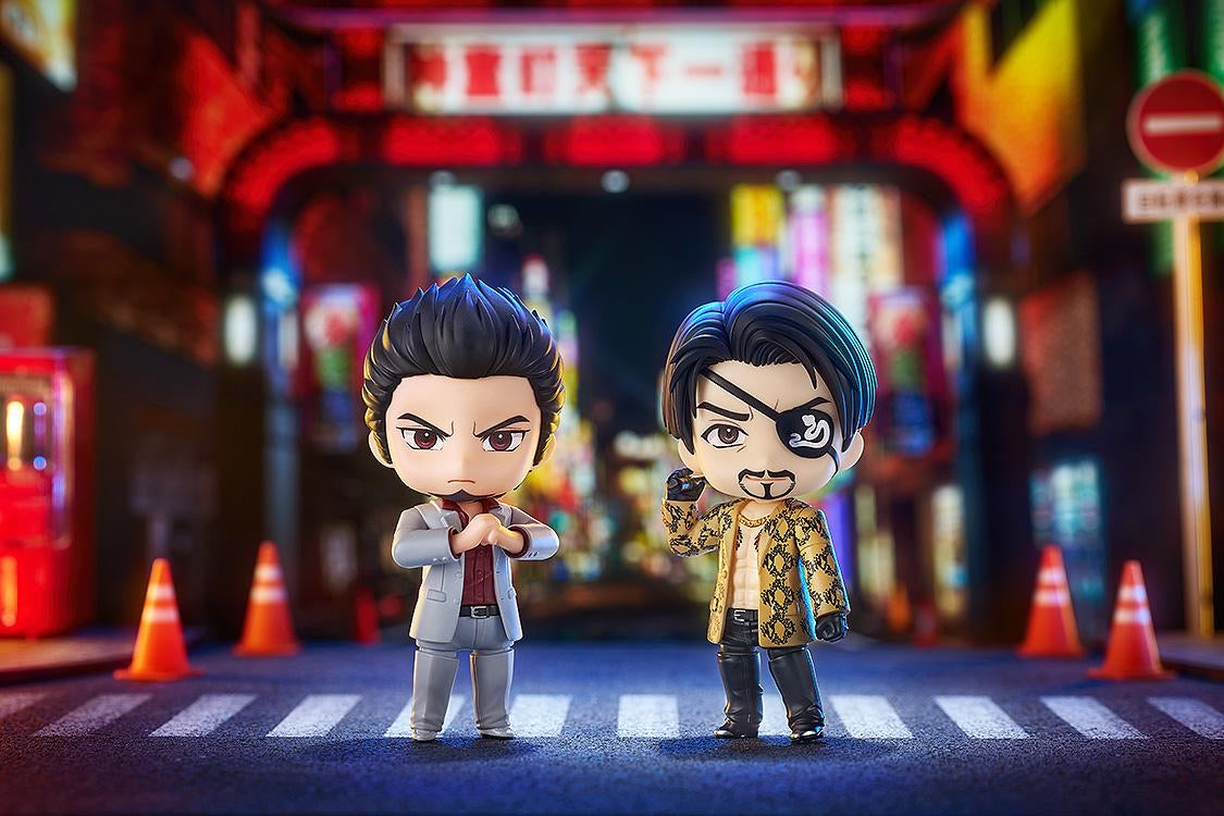 Kiryu and Majima Nendoroid figures standing side-by-side on a crosswalk, set in a dynamic nighttime city street diorama.