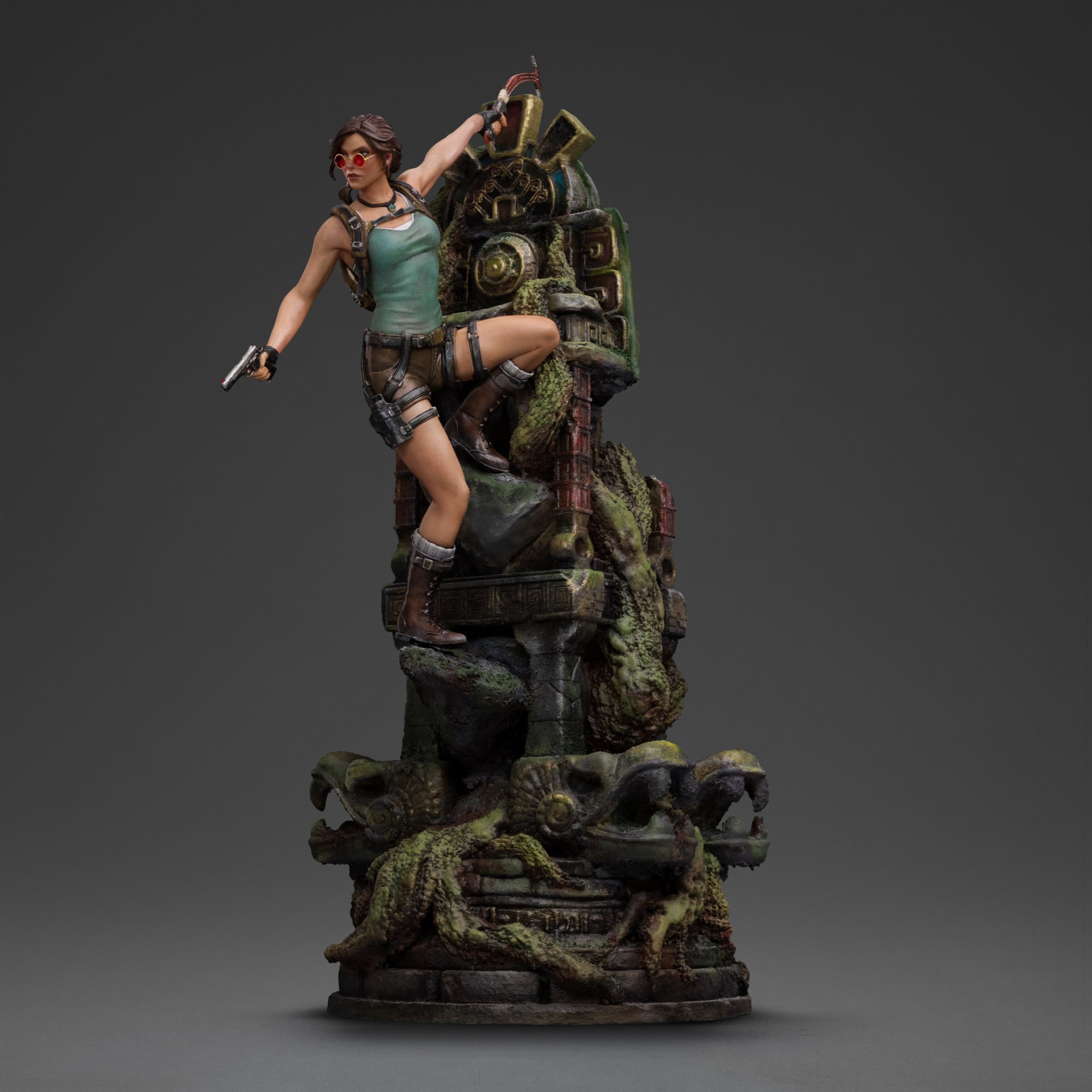 An angled front view of the Lara Croft statue with sunglasses and pistol, highlighting the detailed jungle ruins base.