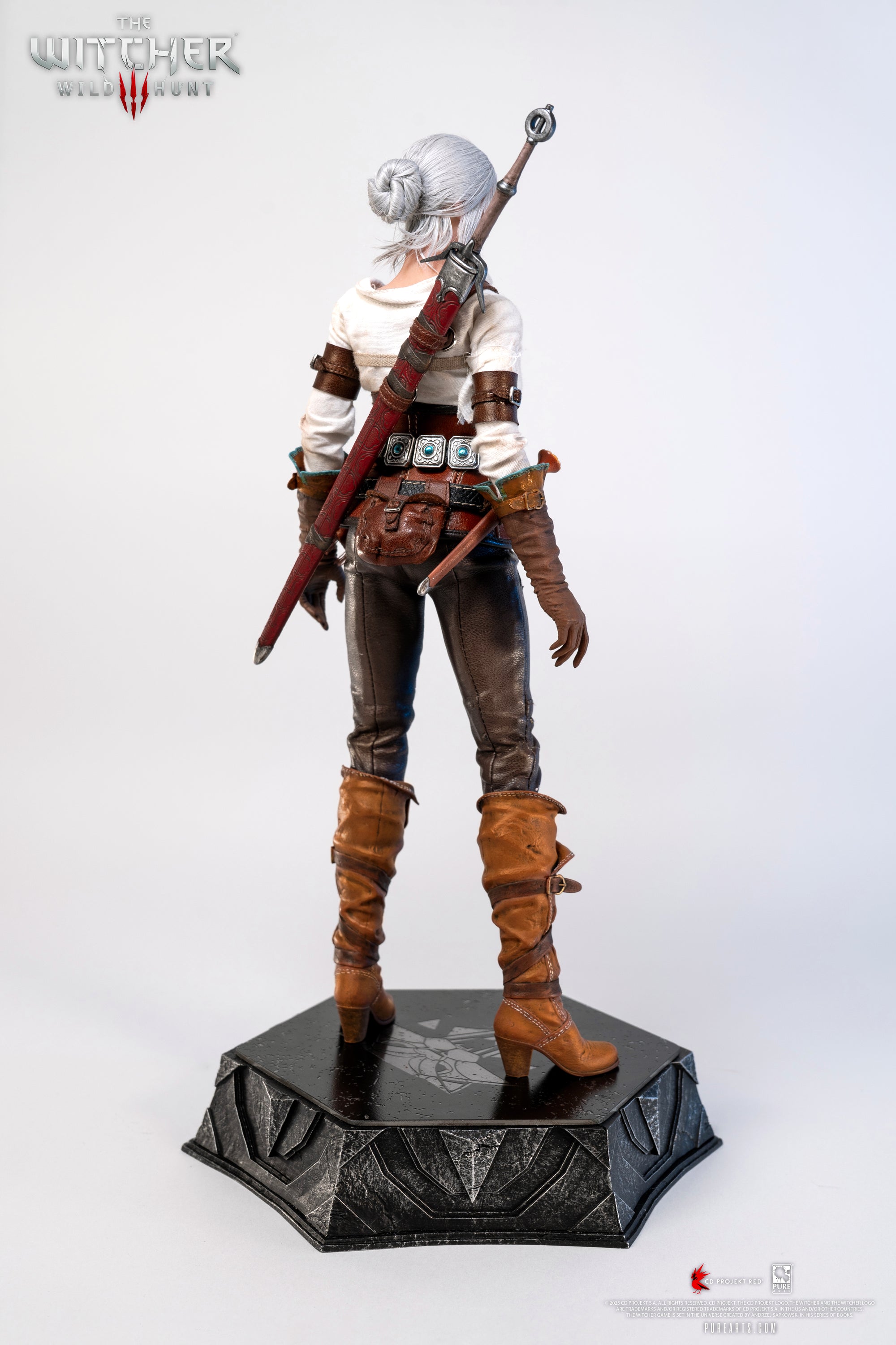 Rear view of the Ciri figure, showing her back, the sword sheath, and the straps of her harness.