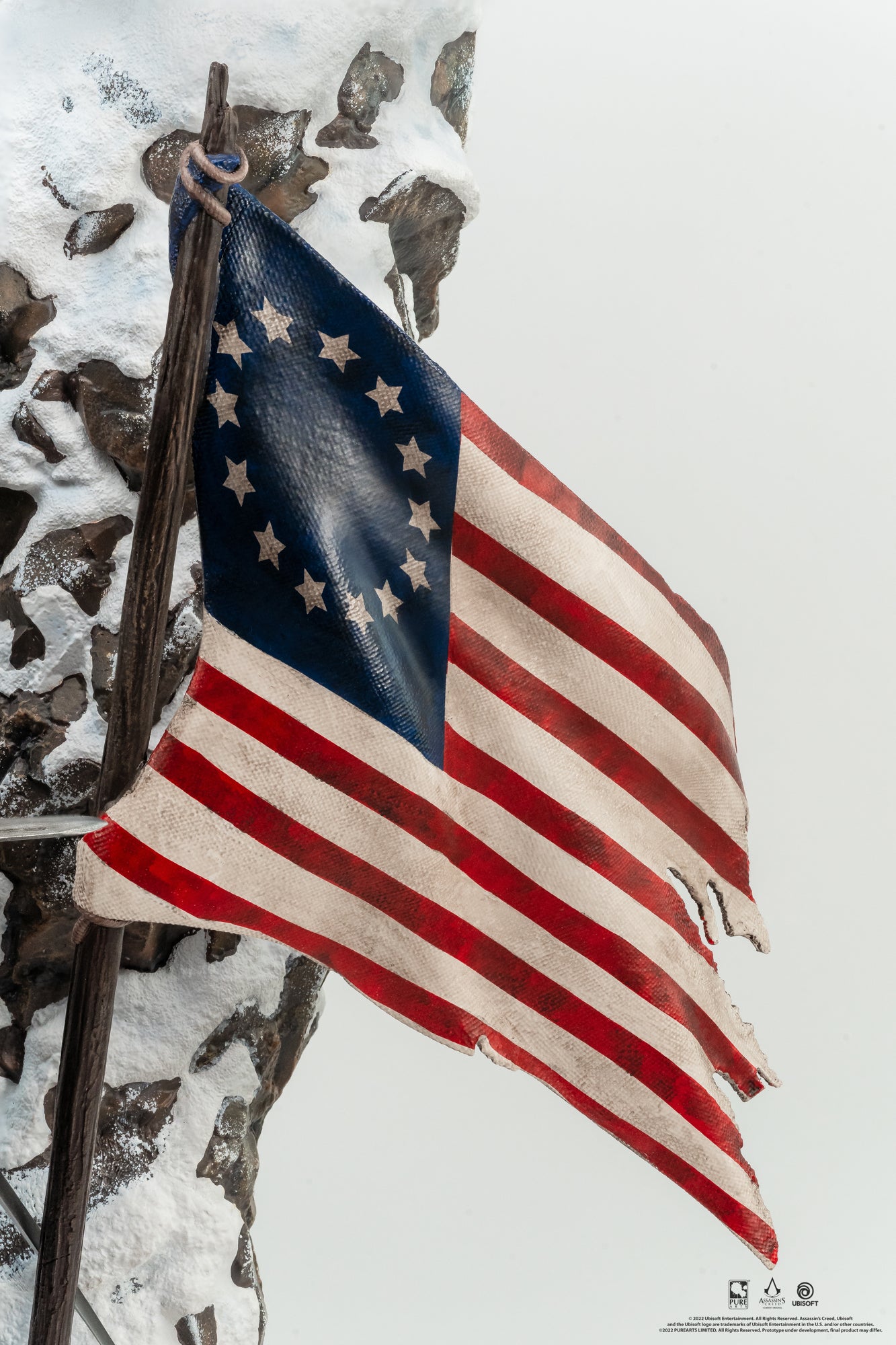 A close-up of the tattered, star-spangled American flag on the Animus Connor statue, highlighting the fabric texture and details.