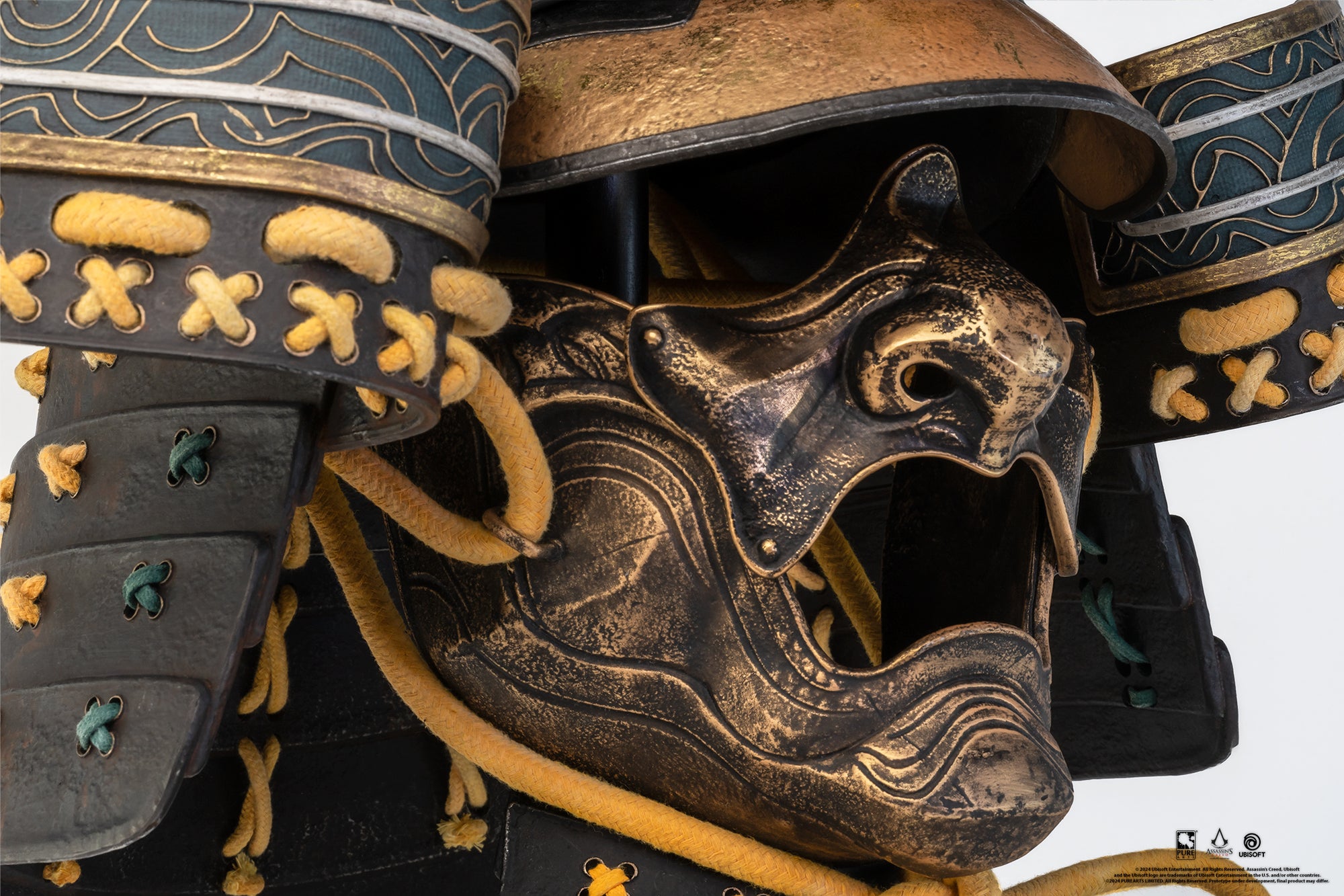 Profile view of the PureArts Yasuke helmet showing the weathered gold and black facemask (mempo) with intricate details and a stylized, open mouth.
