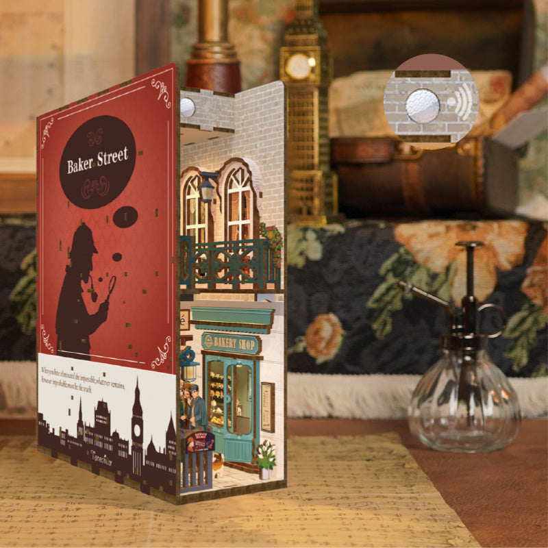 Angled view of the book nook, highlighting the miniature facade, bakery shop, and the motion sensor LED light on the ceiling.