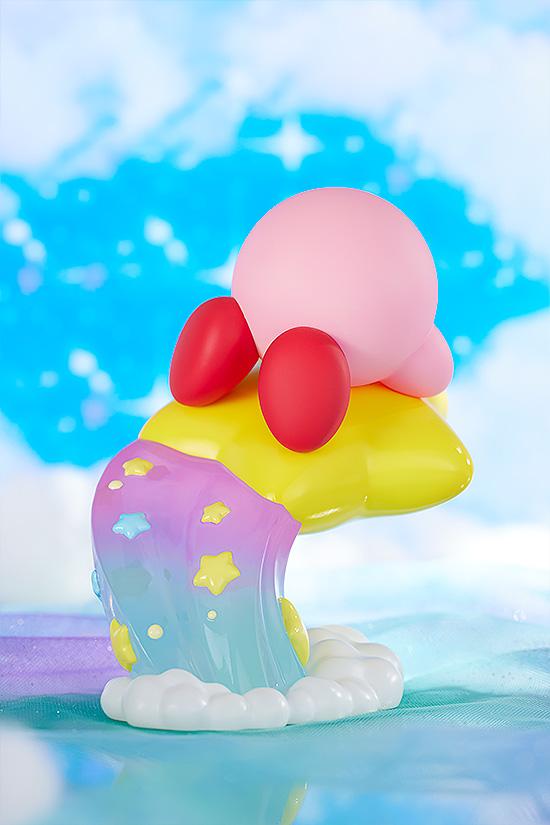 Rear scenic angle of the Kirby figure highlighting the colorful pastel rainbow jet stream base within a fluffy blue and white cloud diorama.