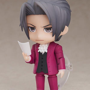 Miles Edgeworth Nendoroid figure behind wooden courtroom desk with angry faceplate and Japanese Hold It text plate.
