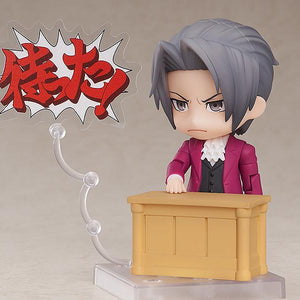 Ace Attorney Miles Edgeworth Nendoroid figure pointing finger with Japanese Objection text plate on clear stand.