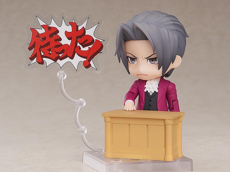 Ace Attorney Miles Edgeworth Nendoroid figure pointing finger with Japanese Objection text plate on clear stand.