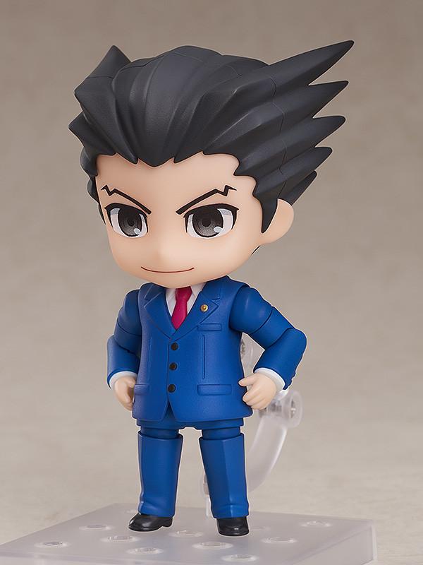 Phoenix Wright Nendoroid figure holding green Magatama accessory on clear display stand.