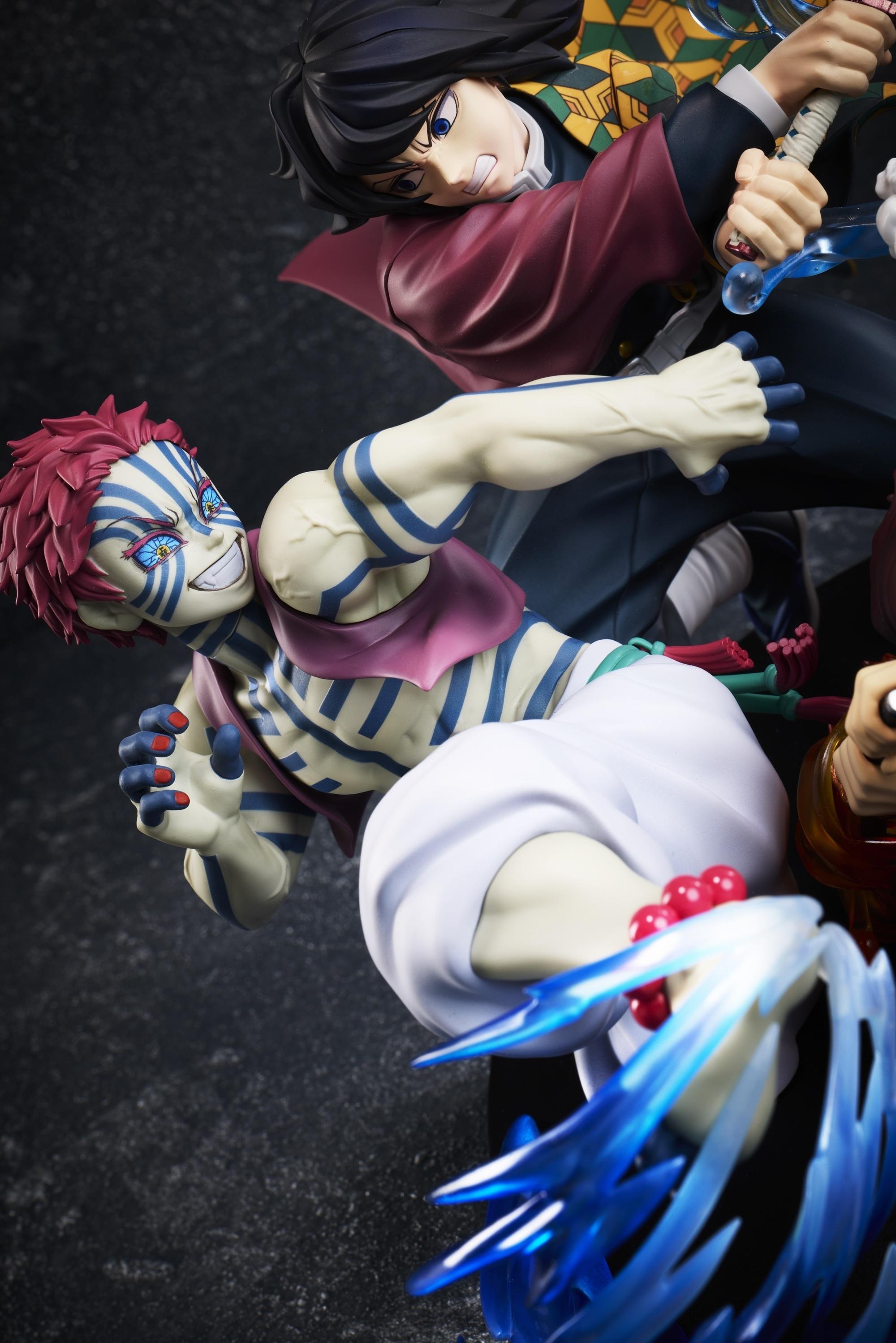 Close-up shot of Upper Moon Three Akaza with blue body tattoos delivering a kick with martial arts splash effect