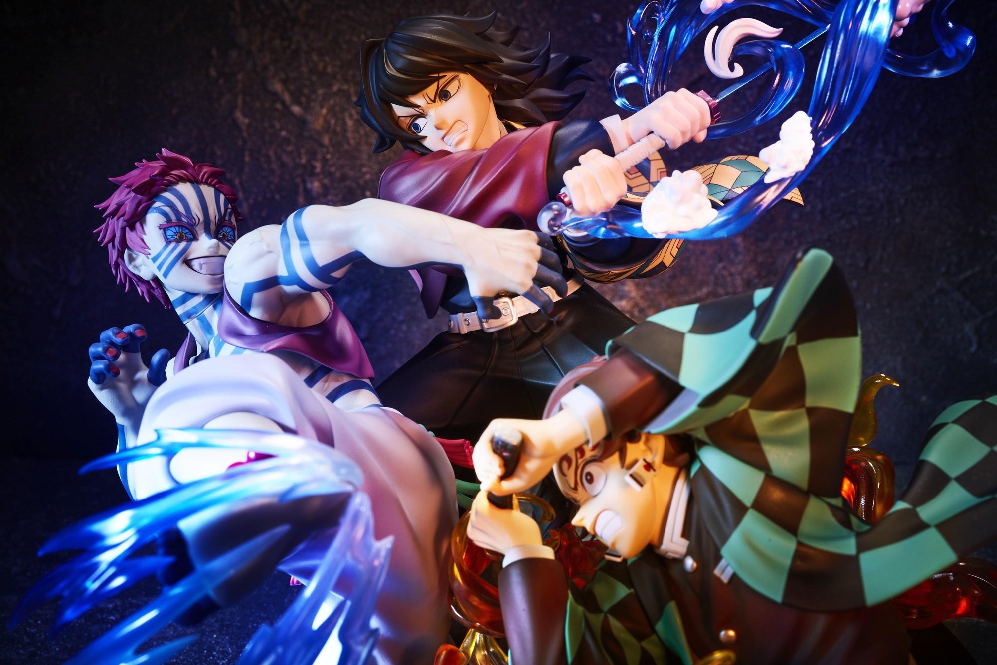 Dynamic low-angle view of Tanjiro, Giyu Tomioka, and Akaza figure under dramatic purple battle lighting