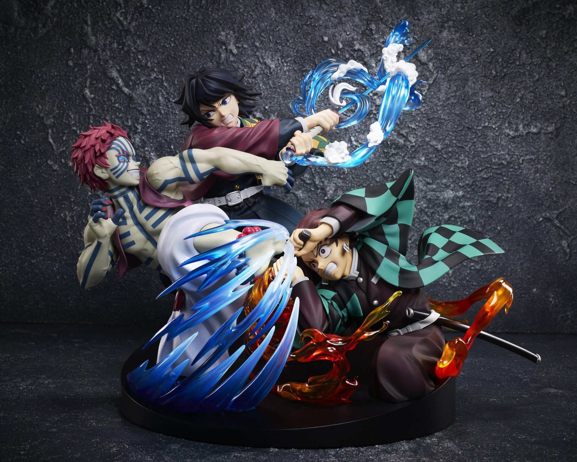 Aniplex Demon Slayer vignette figure featuring Tanjiro Kamado, Giyu Tomioka, and Akaza in a battle scene with fire and water effect parts on a dark background