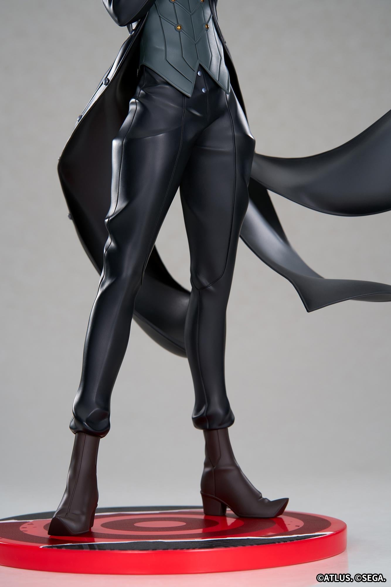 Close-up detail shot focusing on the tailored black trousers, high-heeled dark brown boots, and patterned waistcoat of the Joker scale figure.