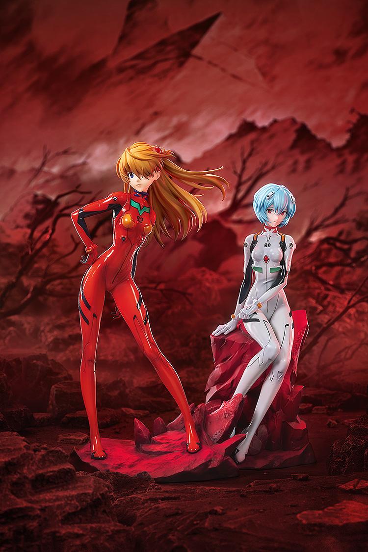 Wide cinematic shot of Asuka Shikinami Langley and Rei Ayanami figures posed together in a desolate red landscape.