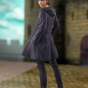 Full body diorama shot of the Eren Yeager figure posed on cobblestones in front of a stone fortress backdrop