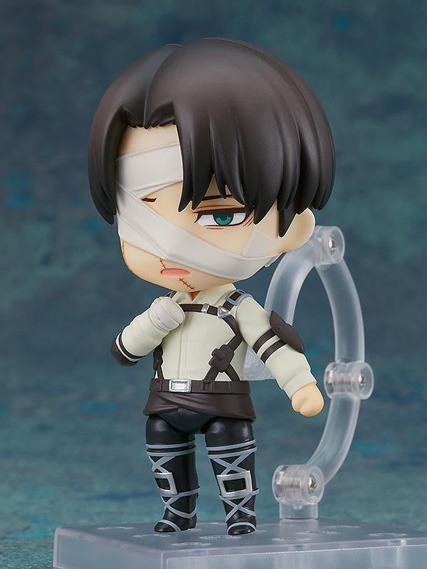 Nendoroid Levi figure using the downcast face plate and posed with his hand near his chest.