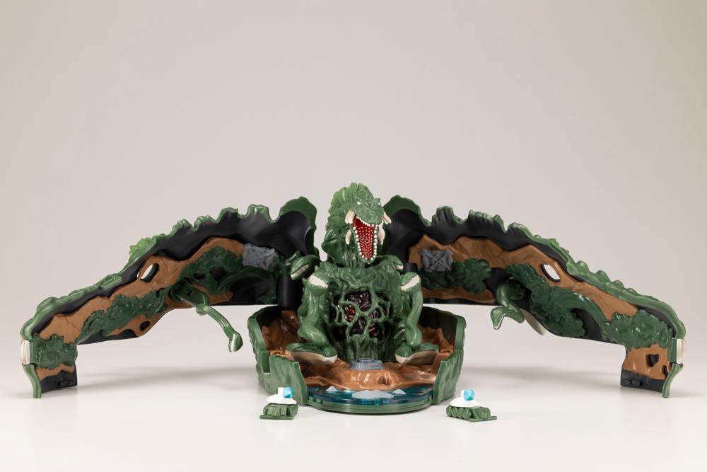 Unfolded Biollante playset with mouth open roaring, vine tendrils, and miniature maser tanks at the base.