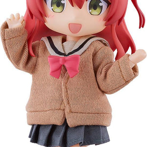 Close-up front view of the Bocchi the Rock! Ikuyo Kita Nendoroid Doll figure with vibrant red hair, green eyes, and a cheerful open-mouthed smile, wearing a brown fabric uniform cardigan with a pink bow against a white background.