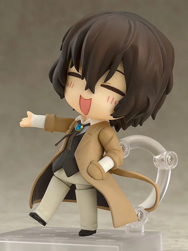 Nendoroid Osamu Dazai figure with the carefree expression face plate, posed with one arm outstretched and eyes closed in laughter.