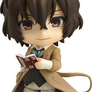 Main image of the Bungo Stray Dogs Nendoroid Osamu Dazai figure, wearing his trench coat and holding his favorite book, "A Guide to Suicide."