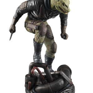 Three-quarter front view of the Caiman figure crouching atop a highly detailed industrial pipe diorama base.