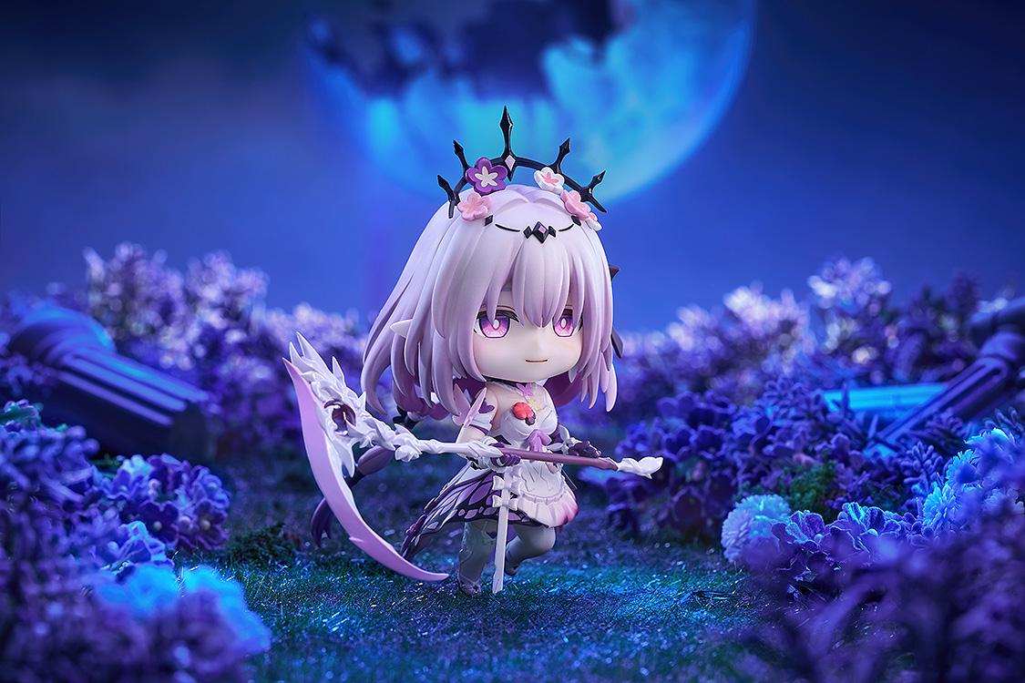 Side angle of the Castorice Nendoroid holding her scythe weapon within a detailed miniature flower field setting beneath a bright, moonlit sky.