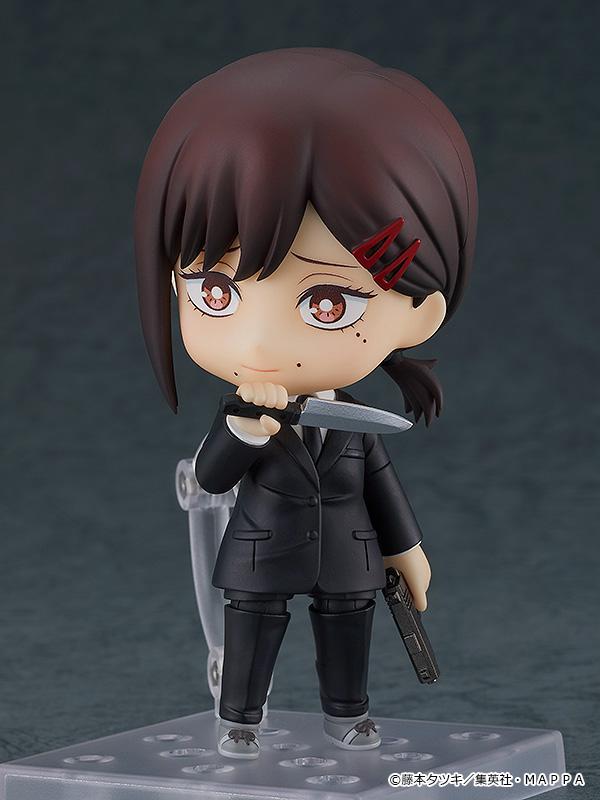 Front view of Nendoroid Kobeni holding a knife in her right hand near her chin and a gun in her left hand, wearing her Public Safety uniform.