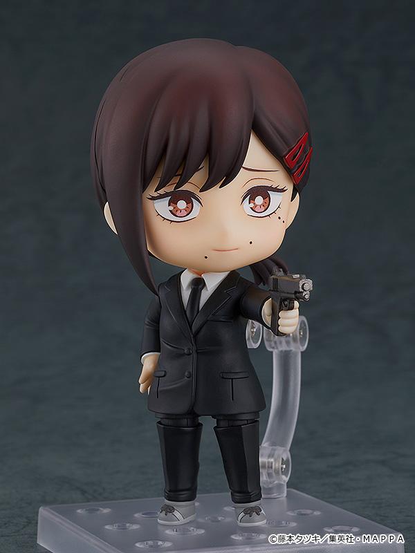 Nendoroid Kobeni figure with the nervous face plate, holding the gun accessory with both hands.