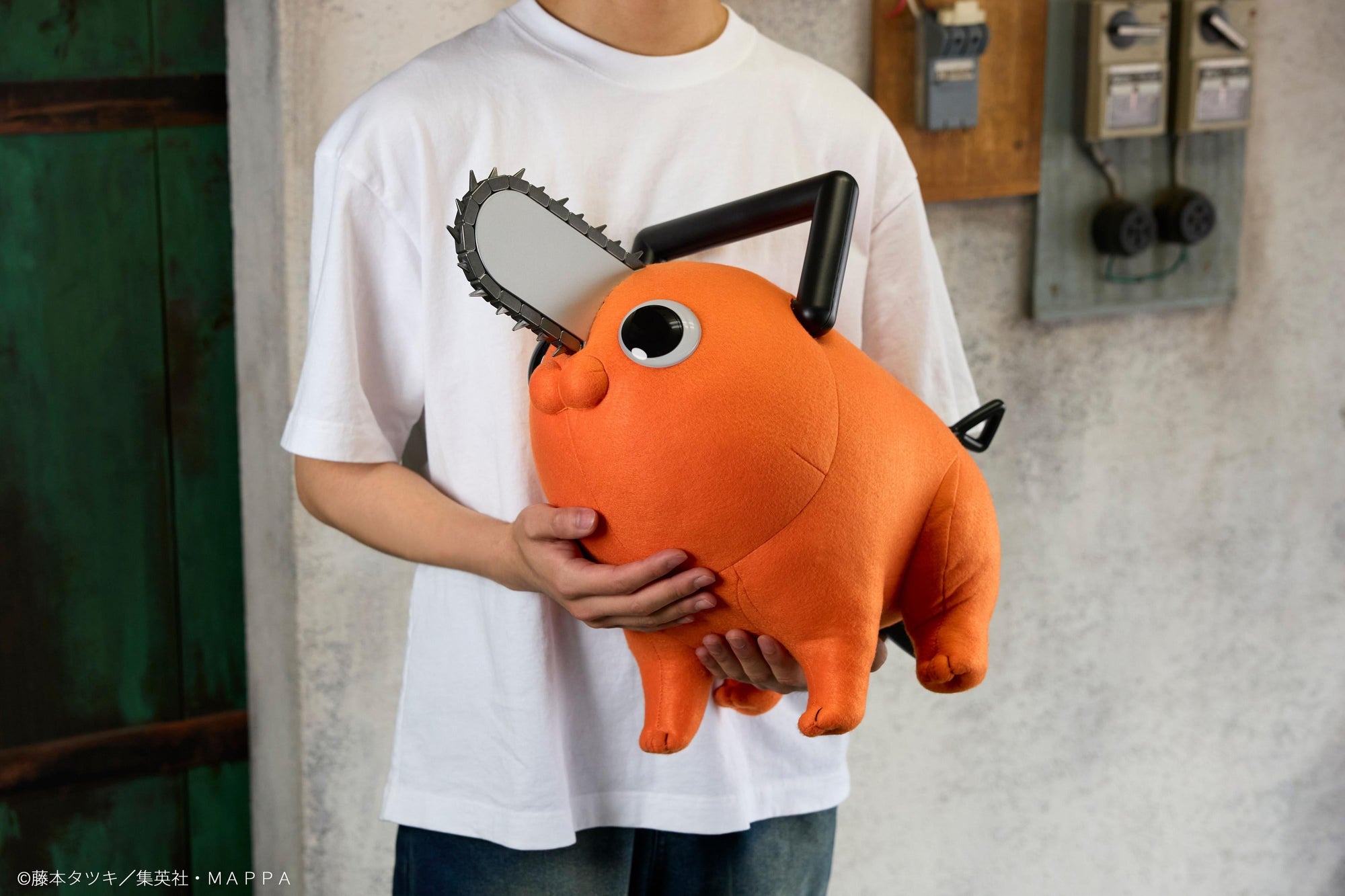 Person holding the Pochita life-size plush doll close to their chest in a lifestyle setting.