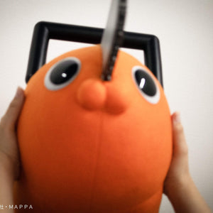 First-person perspective holding Pochita's plush cheeks up close.