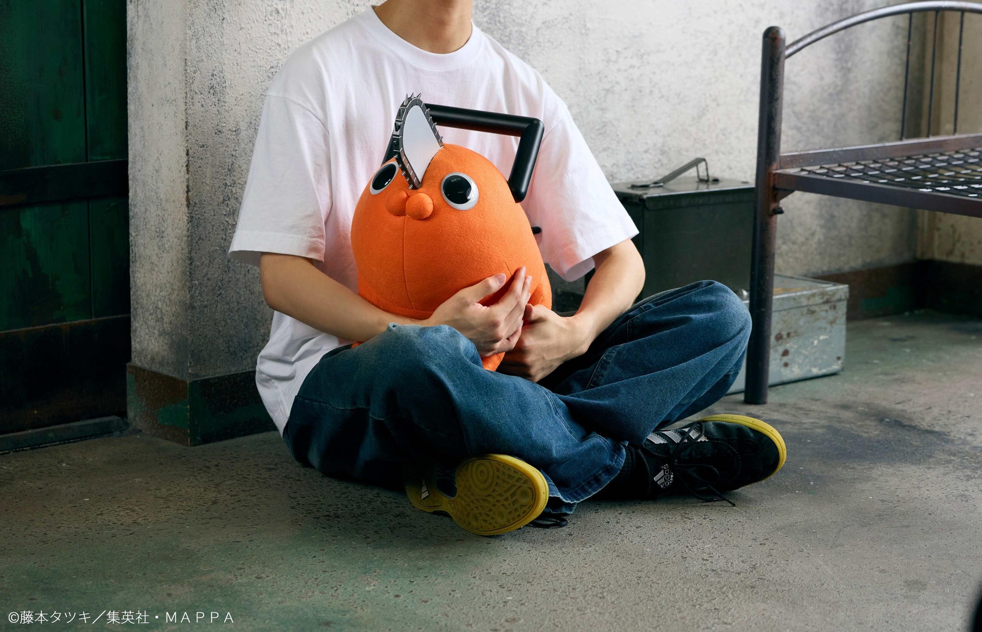 Person sitting cross-legged holding the 60cm Pochita life-size plush doll in their lap.