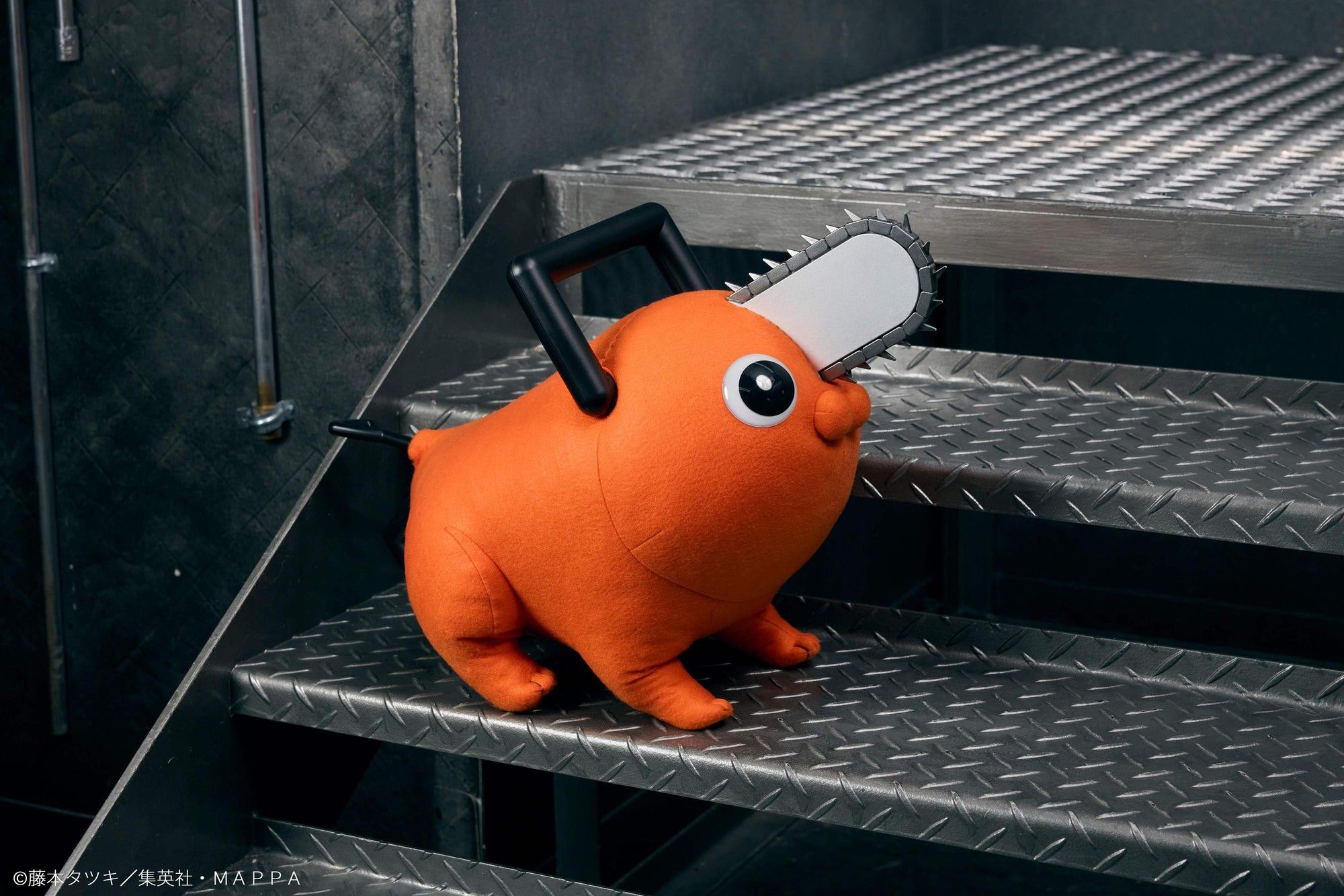 Pochita life-size plush doll standing on metal industrial stairs facing right.
