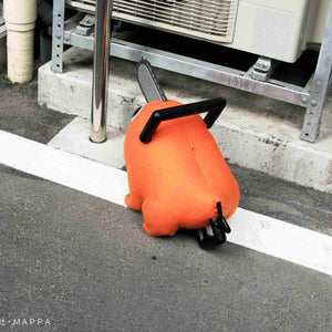 Back view of the Pochita life-size plush doll sitting on pavement outdoors.