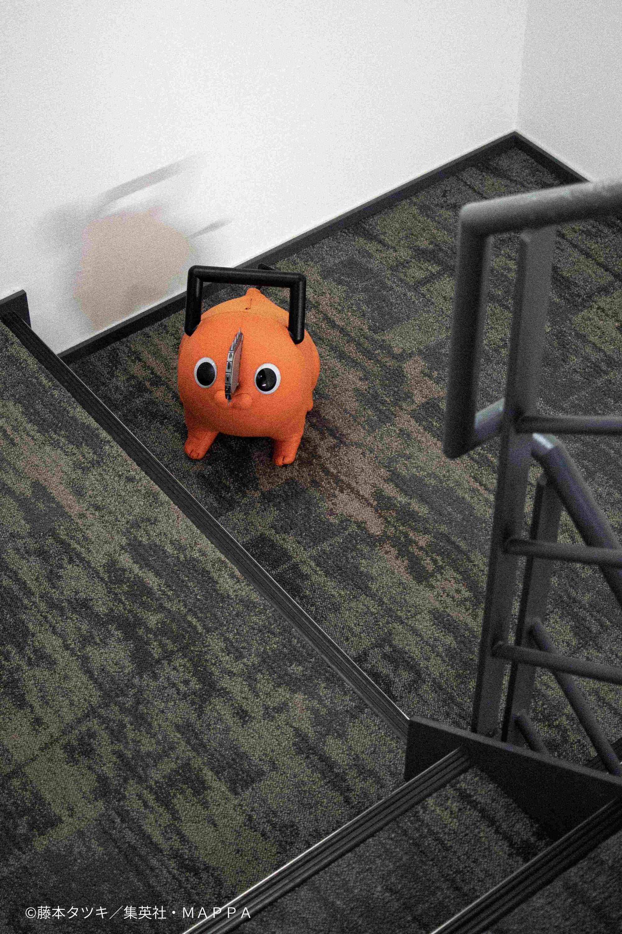 High-angle shot looking down at the Pochita life-size plush doll on carpeted stairs.