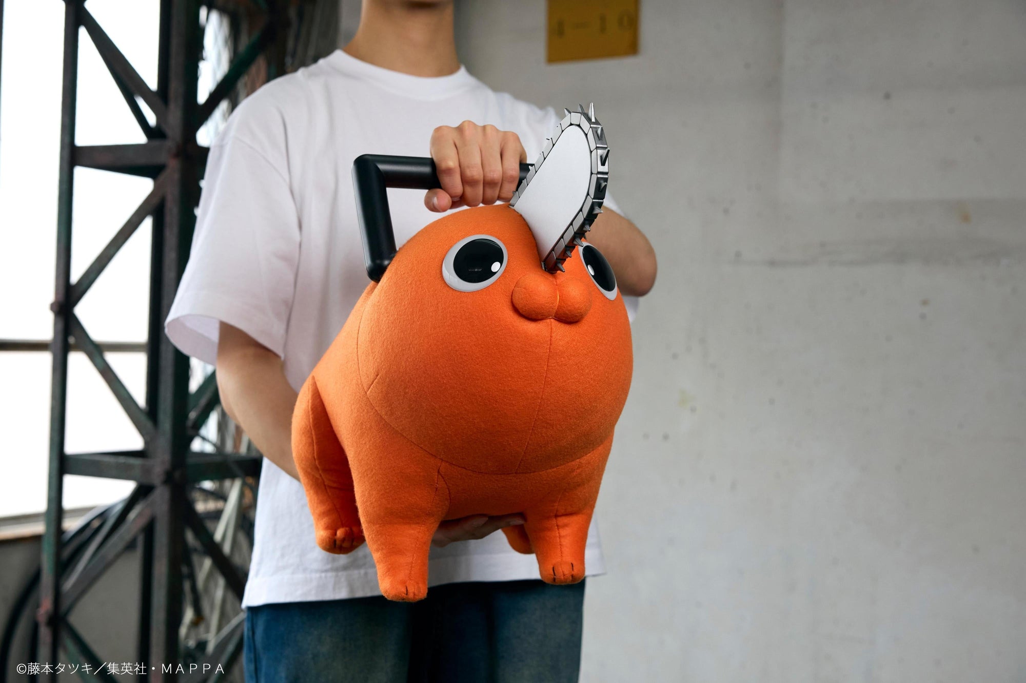Person holding the Pochita life-size plush doll under both arms to show its 60cm scale.