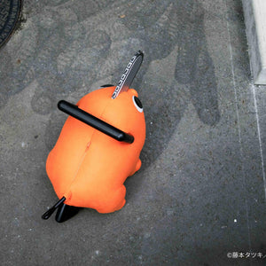 Top-down angle view of the Pochita life-size plush doll standing on outdoor pavement.
