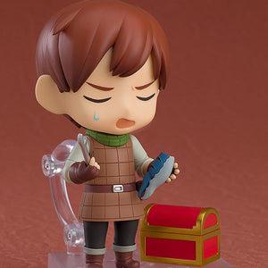 Chilchuck Nendoroid looking exasperated while holding a blue mimic leg accessory next to a treasure chest.