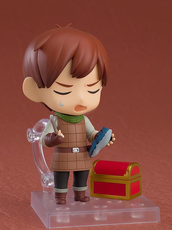 Chilchuck Nendoroid looking exasperated while holding a blue mimic leg accessory next to a treasure chest.