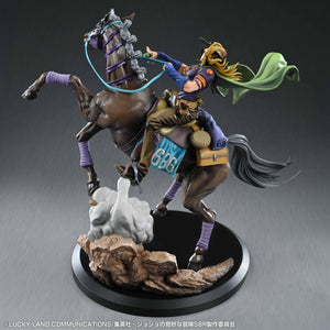 Elevated left three-quarter view of the Chozo Art Collection Gyro Zeppeli & Valkyrie statue, showing Gyro leaning back and pulling the bright blue reins as his horse rears over the rocky dust base.