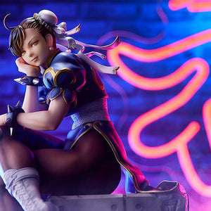 Wide landscape shot of the Chun-Li scale figure set against a vibrant neon wing background.