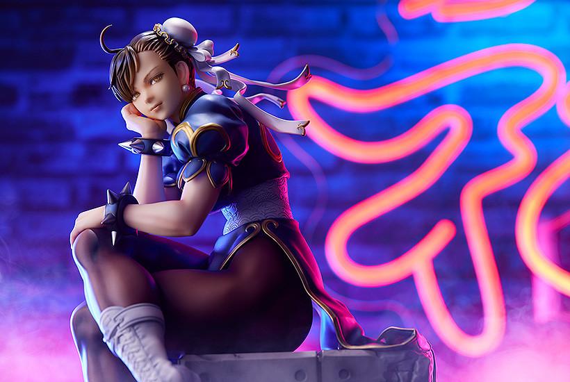 Wide landscape shot of the Chun-Li scale figure set against a vibrant neon wing background.