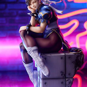 Promotional shot of Chun-Li figure under vibrant pink and blue neon lighting in a city setting.