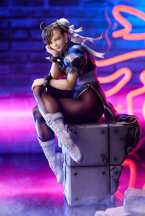 Promotional shot of Chun-Li figure under vibrant pink and blue neon lighting in a city setting.