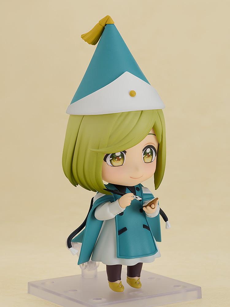 Three-quarter view of the Coco Nendoroid action figure holding her tiny ink wand brush and palm quire notebook accessories in her hands.