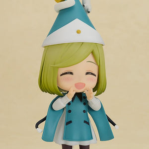 Front view of the Witch Hat Atelier Coco Nendoroid wearing a curled pointy hat with a tiny magical creature on top, showcasing her blushing, wide-mouthed smiling face plate.