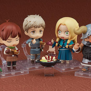 A group display featuring the Senshi, Marcille, Laios, and Chilchuck Nendoroid figures enjoying a dungeon meal together.