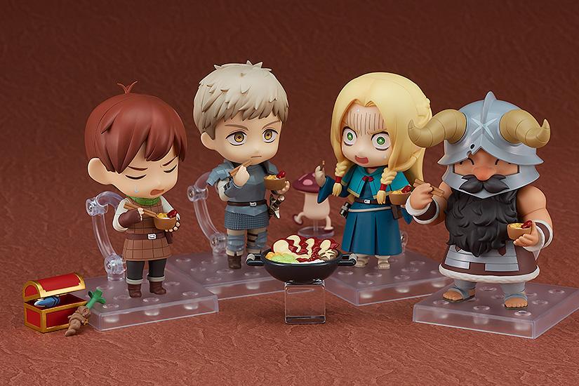 A group display featuring the Senshi, Marcille, Laios, and Chilchuck Nendoroid figures enjoying a dungeon meal together.