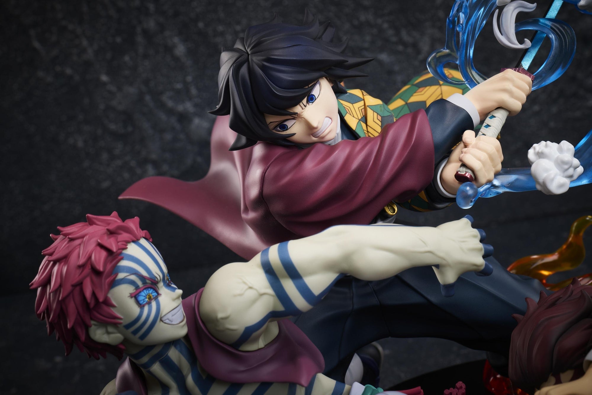 Medium close-up of Giyu Tomioka striking with water effects while Akaza smiles in the Demon Slayer Aniplex figure