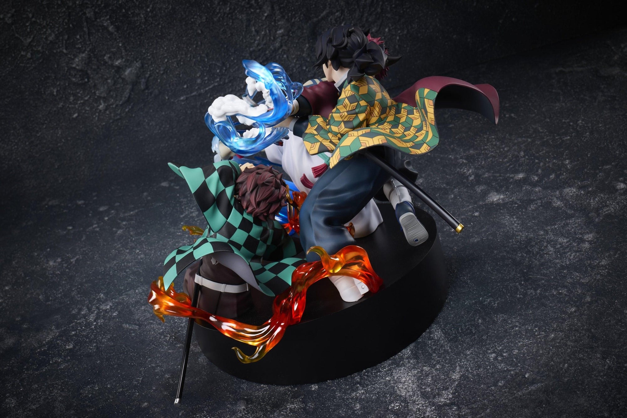 High-angle rear view of the Aniplex Demon Slayer Tanjiro, Giyu, and Akaza figure highlighting haori patterns and flame effect sculpts