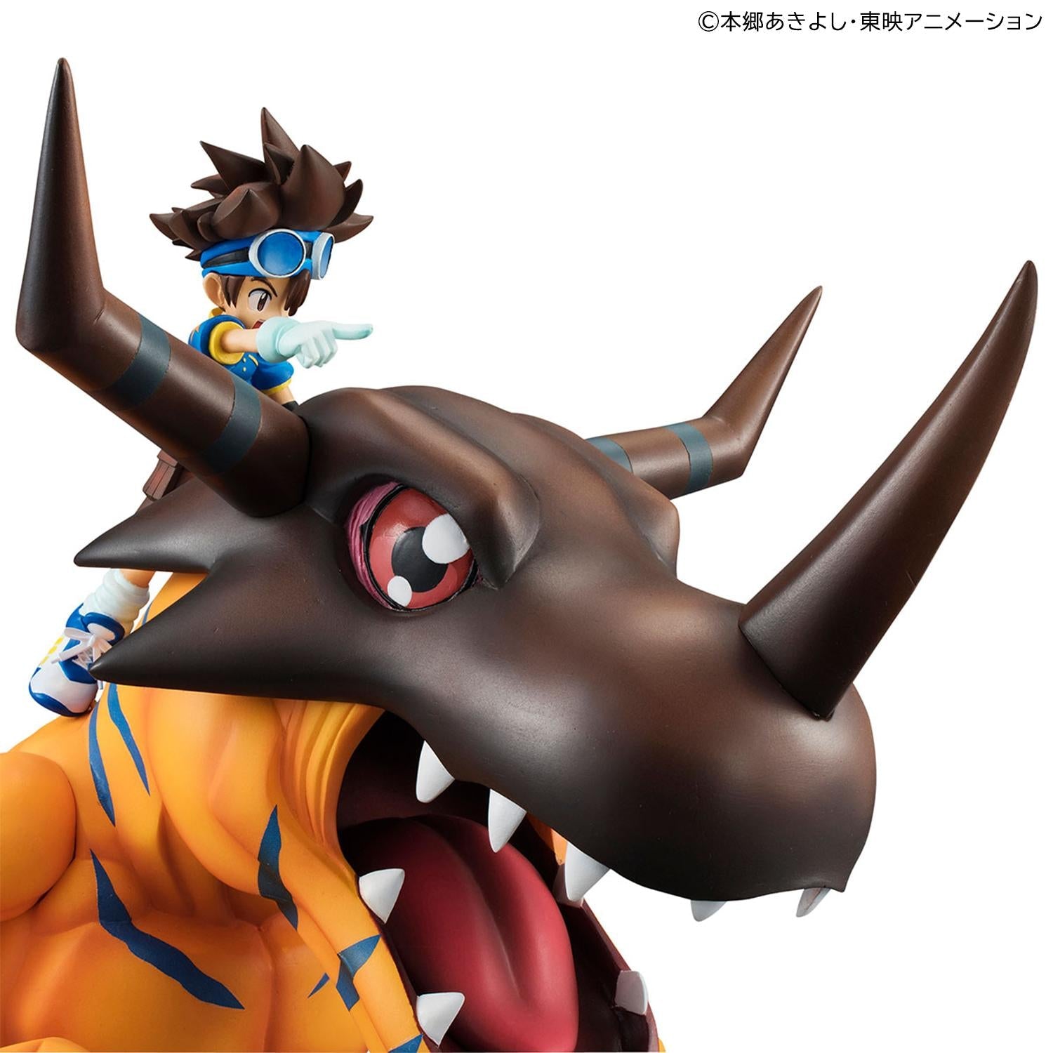 Close-up shot of Greymon's brown helmeted head and open jaw with Tai Yagami pointing forward