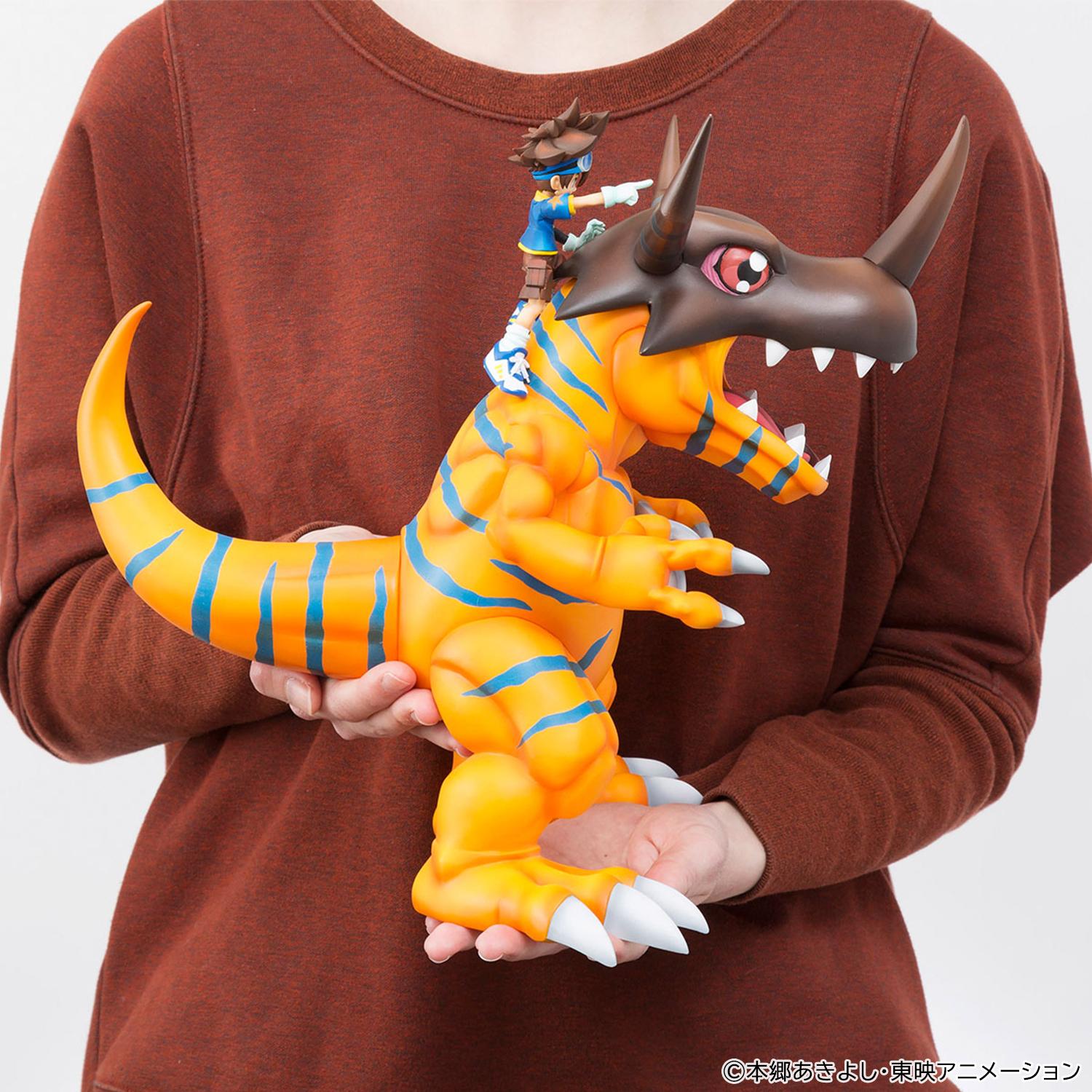 In-hand photo demonstrating the large 25cm size and scale of the Megahouse Precious G.E.M. Greymon figure